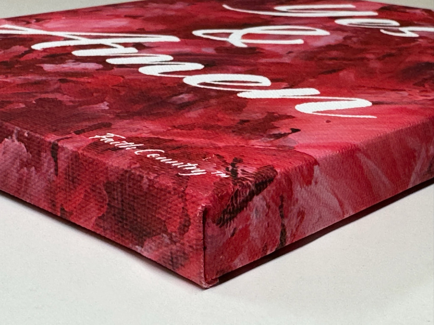 Side view of wrapped canvas art showcasing the text 'Yes & Amen' on a rich red abstract background, highlighting the textured edge detail.
