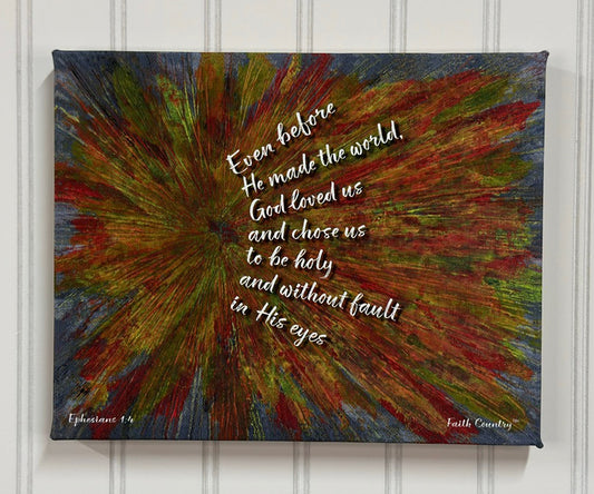 Canvas wall art with a vibrant explosion of warm and cool tones. The text reads 'Even before He made the world, God loved us and chose us to be holy and without fault in His eyes' from Ephesians 1:4. Artwork by Faith Country™.