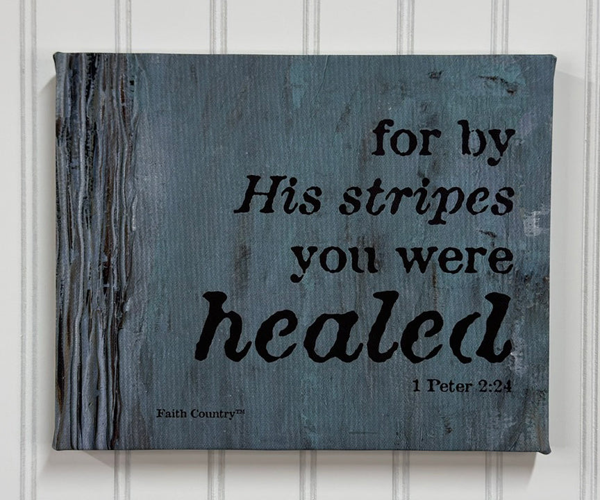 Faith-inspired canvas art with the text 'For by His stripes you were healed - 1 Peter 2:24' in black on a distressed blue-gray wood-textured background. Rustic and spiritual decor piece.