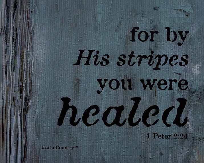 Close-up of faith-based wall art featuring 'For by His stripes you were healed - 1 Peter 2:24' text on a textured blue-gray background with a woodgrain effect.