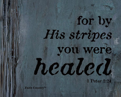 Close-up of faith-based wall art featuring 'For by His stripes you were healed - 1 Peter 2:24' text on a textured blue-gray background with a woodgrain effect.