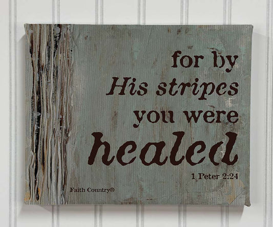 Canvas print of 1 Peter 2:24 scripture art – ‘By His Stripes You Were Healed’ – styled on vertical panel wall.