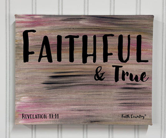 Canvas wall art with the words ‘Faithful & True’ in bold black typography, based on Revelation 19:11. Neutral background with pink and gray strokes.