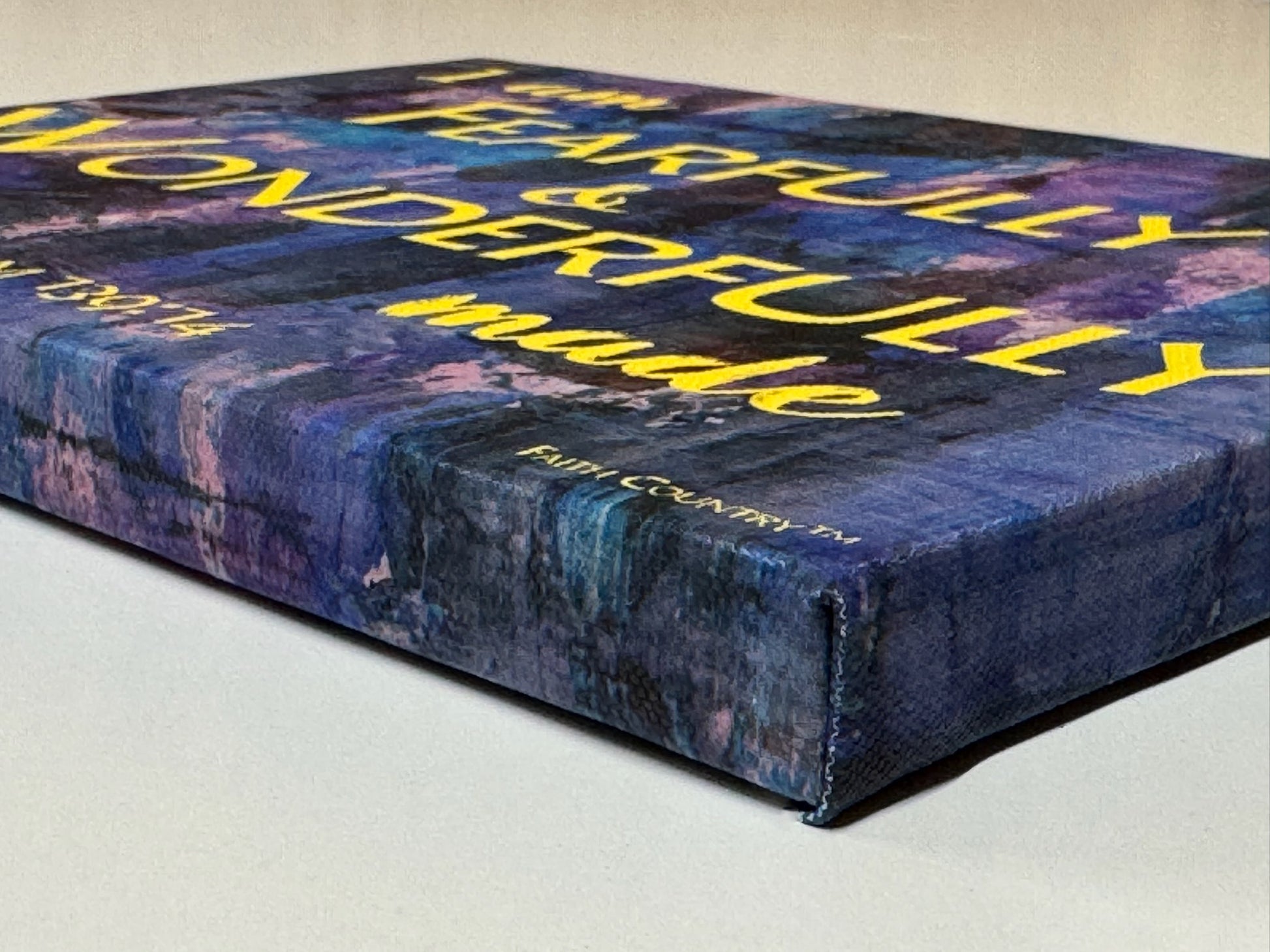 Side view of wrapped canvas art displaying 'I am fearfully & wonderfully made,' highlighting the bold textured edges and vibrant blue and purple color palette.